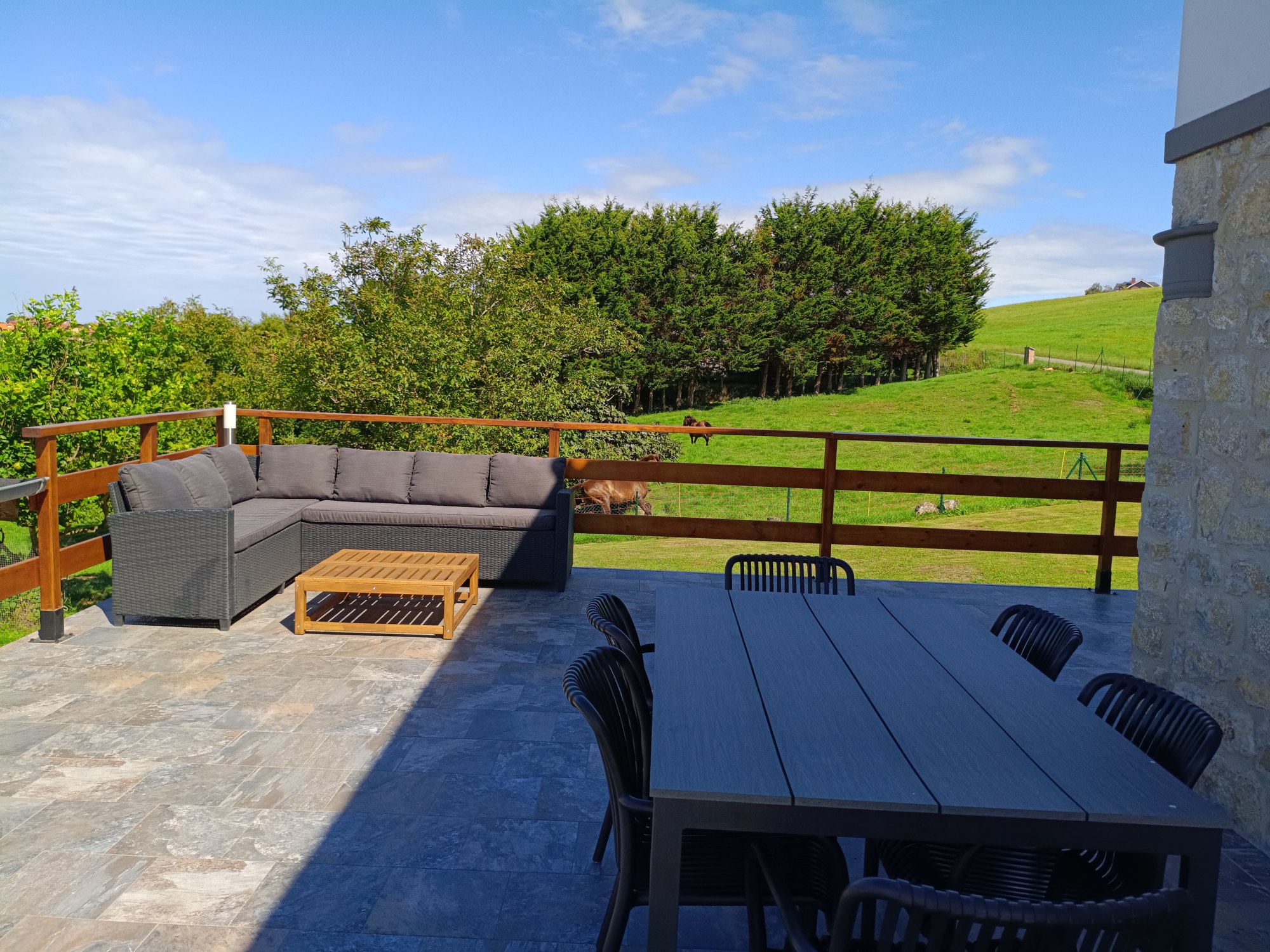 Terraza de La Tadorna con sofá, mesa exterior y vistas al campo